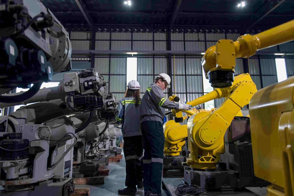 Engineers inspecting robotic arm